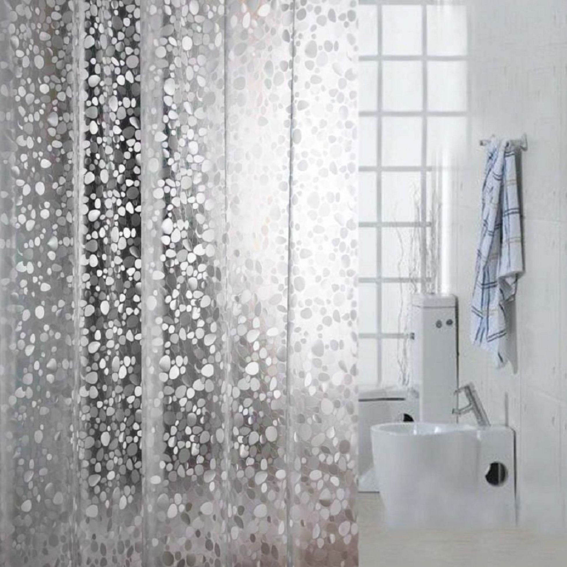 A small bathroom with clear shower curtains.