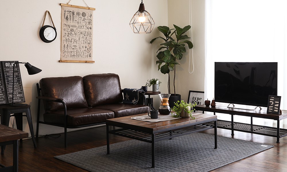 A modern living room featuring the Sanctum Leather Sofa. Detailed with wood and metal finishes.